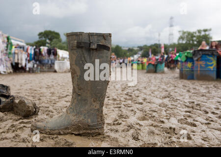 Stivali in gomma sono visti a piedi attraverso i campi fangosi di azienda agricola degna durante il 2014 Festival di Glastonbury nel Somerset, Giugno 2014.. Foto Stock