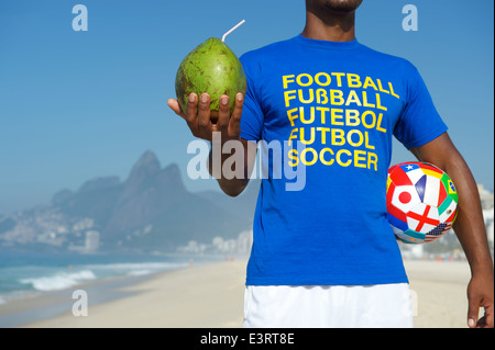 Calcio brasiliano giocatore indossa international football shirt recanti una sfera con World Team Cup di bandiere e di un fresco verde coco Foto Stock