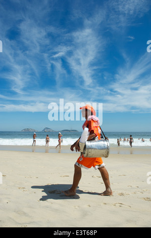 RIO DE JANEIRO, Brasile - 10 Marzo 2013: Brasiliano spiaggia di vendita del fornitore del Sud America tè mate passeggiate in uniforme lungo la riva Foto Stock