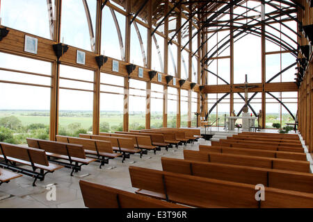 Gretna, Nebraska, Stati Uniti d'America. Il 3 giugno, 2014. Guardando ad ovest dalla parte posteriore del Santuario della Sacra Famiglia, 23132 Pflug Road, Gretna, ne è stato aperto nel 2002. Progettato da architetti BCDM di Omaha, Nebraska. L'unica chiesa in scogliere guardando oltre il Platte Valley è visibile da entrambe le direzioni sulla Interstate 80. Il santuario è con pareti in vetro, con supporti che trattengono il suo 45-ft. tetto alto. Un uomo bolle di flusso lungo un percorso tagliato lungo la passerella per l'ingresso e poi nel pavimento della navata. © Kevin E. Schmidt/ZUMAPRESS.com/Alamy Live News Foto Stock