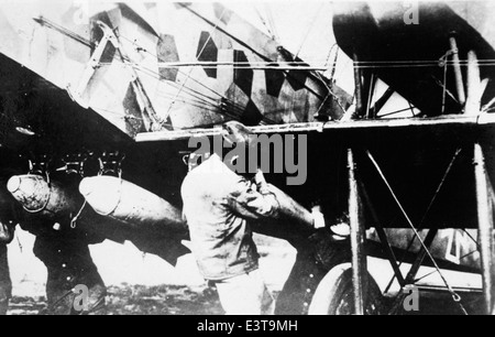 Questa fotografia della collezione di Lou Larson mostra un biplano, probabilmente della prima guerra mondiale, dotato di una bomba aerea. L'aereo è mimetizzato con motivi a losanga, comunemente usati nella grande Guerra per occultamento. L'immagine evidenzia l'uso precoce dei bombardamenti aerei in combattimento, un cambiamento significativo nelle tattiche militari durante la prima guerra mondiale Foto Stock