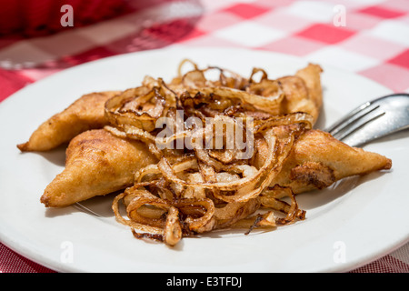 Kreplach fritti (ebreo polpette riempite con la carne di suolo) servita con cipolle Foto Stock