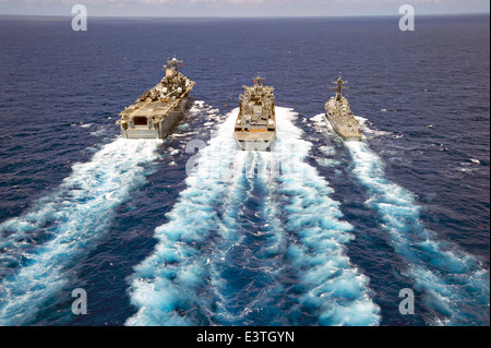 US Navy Amphibious Assault nave USS Peleliu e Arleigh Burke-class missile destroyer USS Spruance durante un rifornimento in mare con Sealift militare il comando rapido supporto di combattimento nave USNS Ranieri durante gli esercizi RIMPAC Giugno 24, 2014 al largo delle Hawaii. Foto Stock