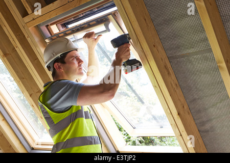 Operaio edile mediante trapano alla finestra di installazione Foto Stock