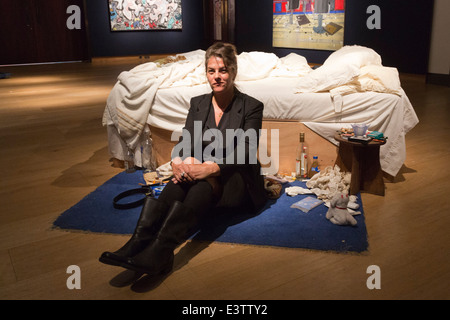 Tracey Emin pone con la sua famosa opera 'My Bed" (1998) di Christie's, Londra, prima di un'asta. Foto Stock