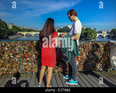 Parigi, Francia, turismo giovane sul Fiume Senna ponte Pont des Arts con amore serrature, Donna in abito rosso, in piedi, posteriore Foto Stock