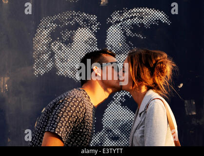 Brighton, Sussex, Regno Unito. Il 29 giugno, 2014. Un paio di rubare un bacio da baciare la statua sul lungomare di Brighton Foto Stock