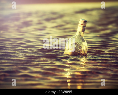 Bottiglia in acqua al tramonto, retro instagram effetto vintage. Foto Stock