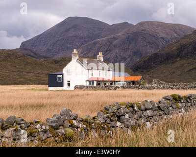 Remote dipinte di bianco casa in Camasunary bay con Red Cuillin montagne (Marsco & Ruadh Stac) oltre, Isola di Skye, Scotland, Regno Unito Foto Stock