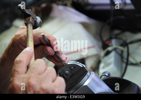 Gioielliere conia decorazioni di argento in officina di Toledo Foto Stock