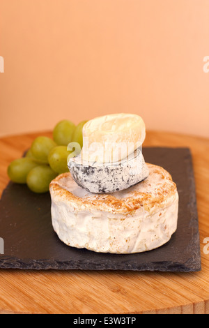 Pila di formaggio camembert e uva sulla tavola di legno Foto Stock