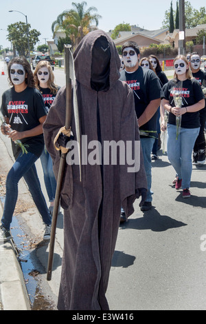 Vestito di 'Grim Reaper' costumi, alta scuola gli studenti partecipano a una drammatizzazione di un incidente stradale causato dalla guida in stato di ebbrezza per l educazione dei compagni di scuola di Anaheim, CA. Nota grottesca di trucco e 'ogni quindici minuti di magliette fornite dall'organizzazione sponsorizza l'evento. Foto Stock