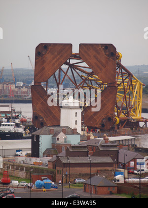 Oil Rig nave di sostegno, Magnus con tre TUG barche di traino di un impianto di trivellazione petrolifera sovrastruttura verso l'entrata del fiume Tyne. Foto Stock