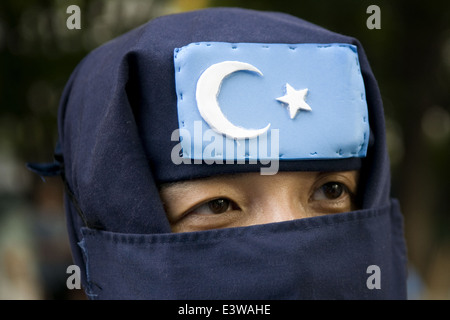 Una velata sostenitore del Turkestan movimento islamico (TIM) precedentemente noto come l'Oriente Movimento islamico del Turkestan (ETIM) fondata da Uyghur jihadisti che prendono parte a una manifestazione di protesta in Xinjiang Uyghur Regione autonoma. Cina occidentale Foto Stock