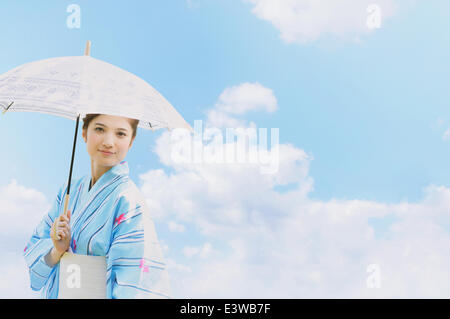 Donna in uno yukata con ombrellone Foto Stock