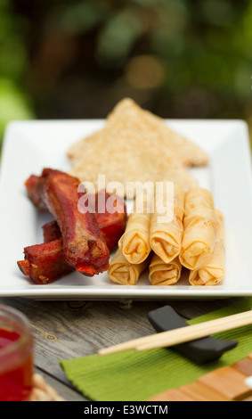 Cucina cinese antipasti su un vassoio esterno, compresi involtini primavera, nervature e di sesamo boreale su pane tostato Foto Stock