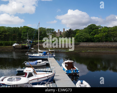Ormeggiate imbarcazioni da diporto Stornoway Harbour con il castello di Lews attraverso l'acqua Foto Stock