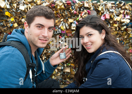 Giovani amanti il bloccaggio di un amore lock lucchetto sul Pont des Arts Parigi a ponte Foto Stock