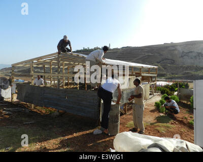 Beirut. Il 29 giugno, 2014. Rifugiati siriano impostare una tenda di fortuna il primo giorno del Ramadan in un campo di rifugiati nel sud del Libano, 29 giugno 2014. Oltre un milione di profughi siriana in Libano è entrato il Ramadan con sospiri e dolore piuttosto che la gioia che di solito accompagna la celebrazione del mese sacro dell'Islam. © Taher Abu Hamdan/Xinhua/Alamy Live News Foto Stock