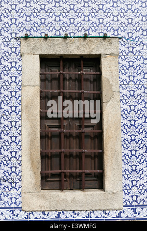 Un ferro antico-finestra sbarrata circondato da azulejo decorativi piastrelle, Ovar, Beira Litoral, Portogallo Foto Stock