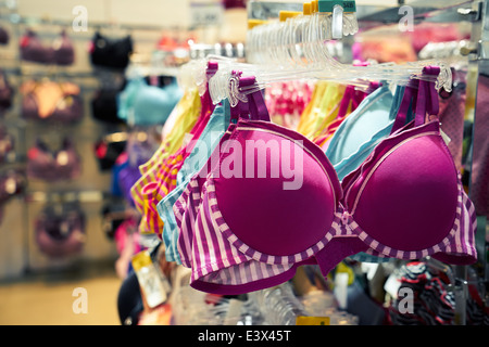 Abbigliamento e retail store: vista del negozio di abbigliamento con il bra impiccato su supporto Foto Stock