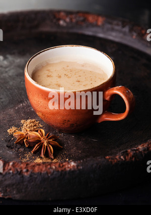 Indian masala tè con spezie e latte su sfondo scuro Foto Stock