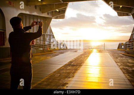 Uomo di scattare una foto fuori porta di traghetto Foto Stock