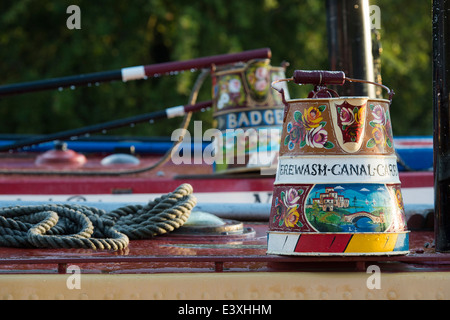 Canal arte popolare caraffe di metallo sui tetti di narrowboats a Braunston storico Canal Rally sul Grand Union Canal Foto Stock