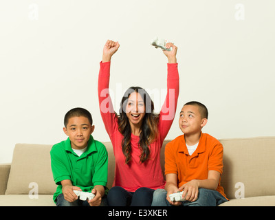 Madre e figli giocare giochi video insieme Foto Stock