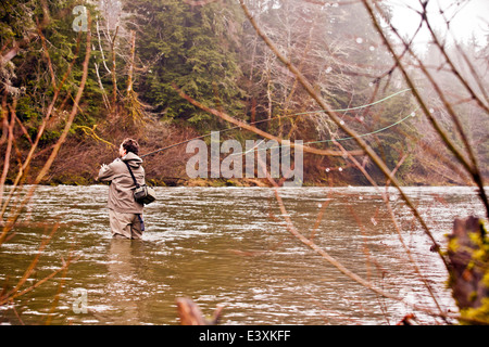 Uomo di pesca a mosca nel fiume rurale Foto Stock