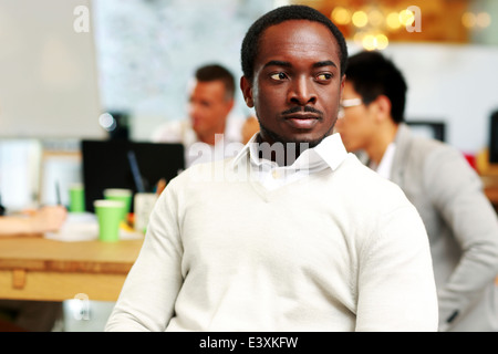Ritratto di un pensieroso uomo africano che guarda lontano in office Foto Stock