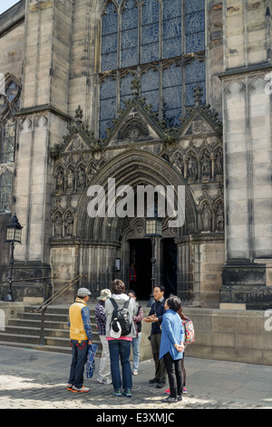 Gruppo di turisti cinesi e guida turistica in piedi fuori la Cattedrale di St Giles, Edimburgo Città Vecchia Foto Stock