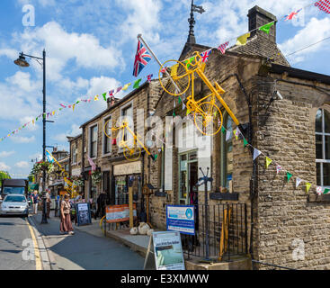 Il West Yorkshire villaggio di Holmfirth entra in contatto con lo spirito del 2014 Tour de France, stadio 2 che passa attraverso la città di domenica 6 luglio 2014. Bunting è strung lungo tutte le strade e alcune aziende locali hanno costruito le biciclette giallo t Foto Stock