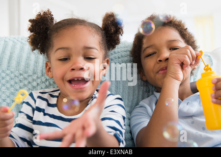 Bambini neri soffiare bolle insieme Foto Stock