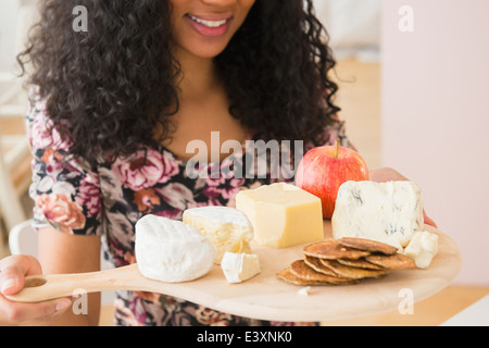 Razza mista donna il trasporto di frutta e formaggi Foto Stock