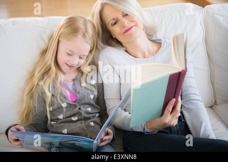 Senior donna caucasica e nipote insieme di lettura Foto Stock