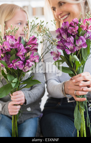 Senior donna caucasica e nipote holding mazzi di fiori Foto Stock