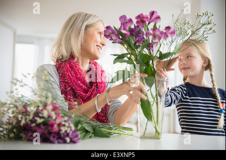 Senior donna caucasica e nipote disponendo dei fiori Foto Stock