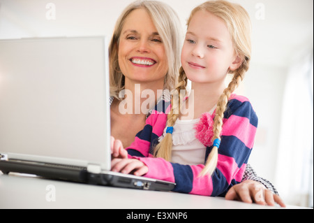 Senior donna caucasica e nipote utilizzando laptop Foto Stock