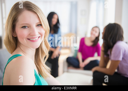 Donna sorridente seduto con gli amici Foto Stock