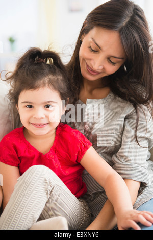 Ispanico madre e figlia seduti insieme Foto Stock