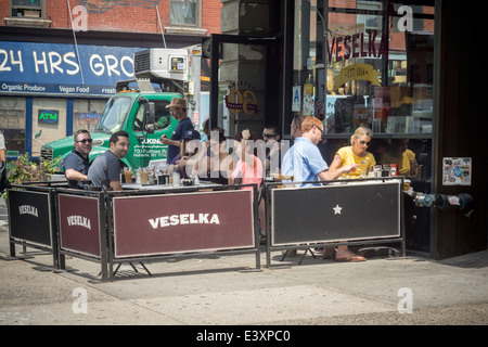 Occupato cenare al fresco presso il cafè sul marciapiede del ristorante Veselka in New York quartiere di East Village Foto Stock