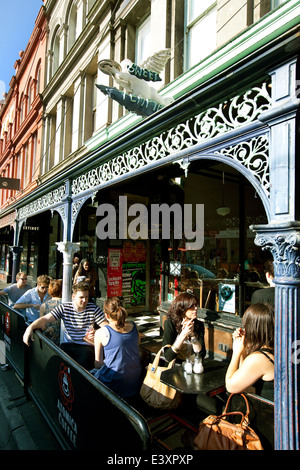 Melbourne Fitzroy scena Brunswick St cafe la cultura, la gente beve caffè sulla strada. Ferro Metallico lavoro vecchio edificio storico. Foto Stock