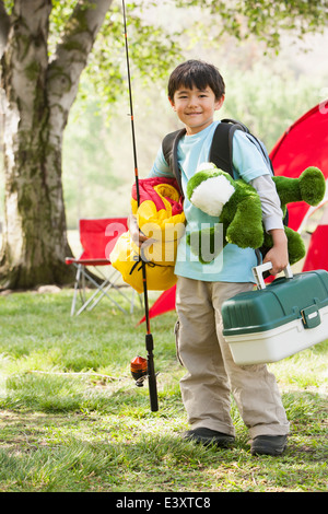 Ragazzo asiatico che trasportano attrezzatura da campeggio Foto Stock