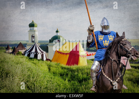 Il cavaliere corazzato su warhorse sopra il vecchio castello medievale e camp Foto Stock