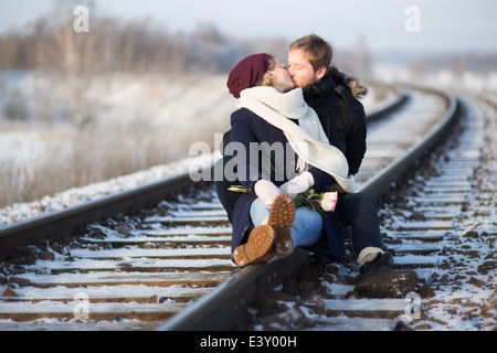 Coppia giovane kissing su ferrovia Foto Stock