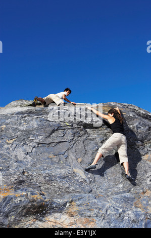 Gli alpinisti scala ripida roccia Foto Stock