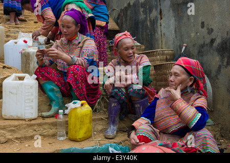 Fiore donne Hmong vendere il vino di riso, può cau mercato, vicino a Bac Ha, Vietnam Foto Stock