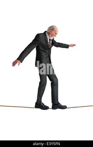 Senior man walking un funambolico isolato su bianco Foto Stock