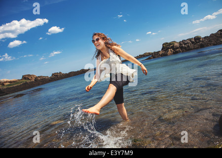 Giovane donna in mare presso la costa rocciosa spiaggia di Biddeford, Maine, Stati Uniti d'America Foto Stock